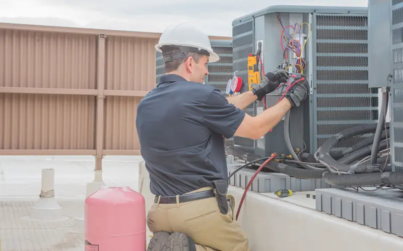 Air Conditioning Tune-Up & Maintenance Image 2_Reduced HVAC technician performing maintenance on an outdoor air conditioning unit