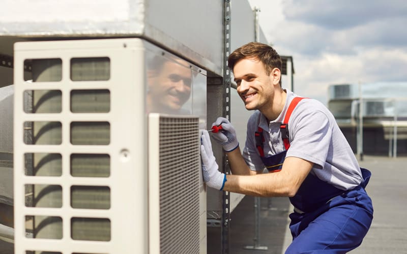 Air conditioner technician fixing an AC unit