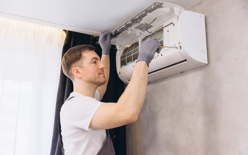 Technician working on an inside air conditioning unit