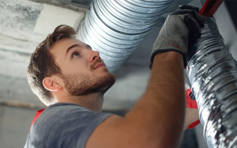 HVAC technician cleaning air ducts in a commercial building