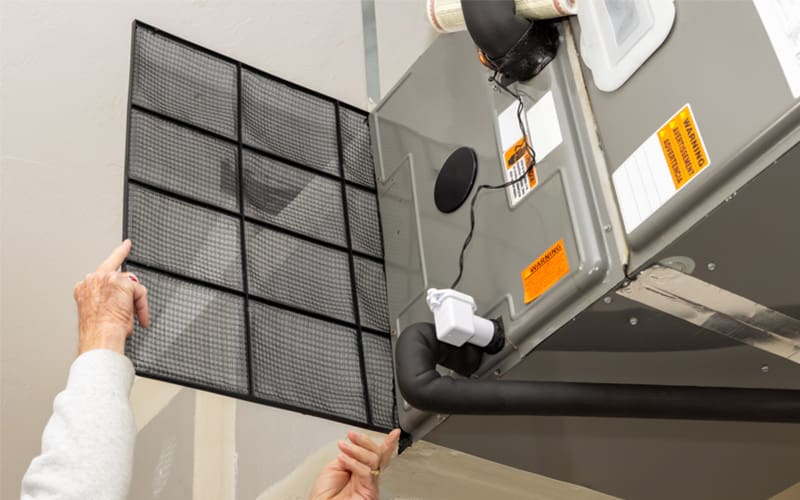 New air filter being installed on an HVAC system