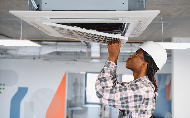 HVAC technician installing a new air filtration unit