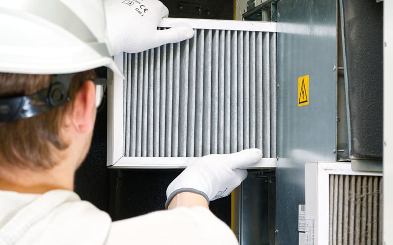 HVAC technician repairing an air filtration system