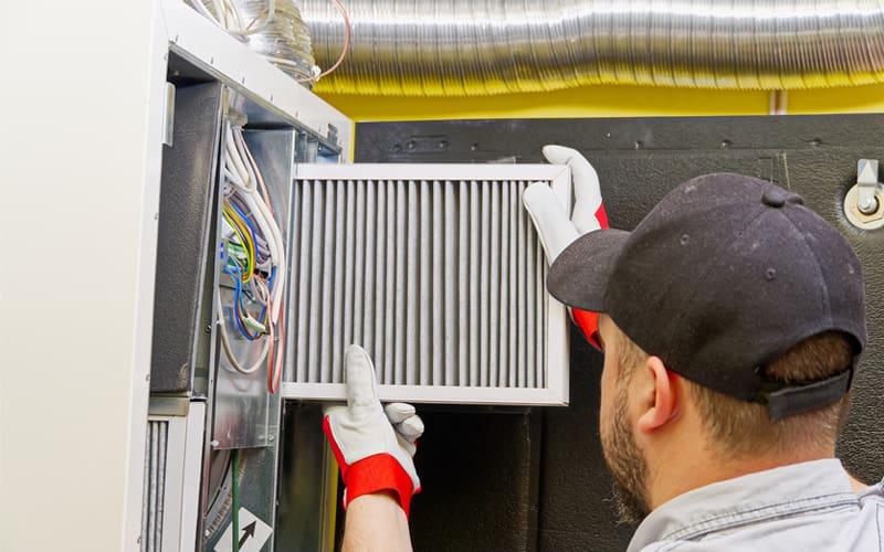 HVAC technician performing maintenance on a furnace