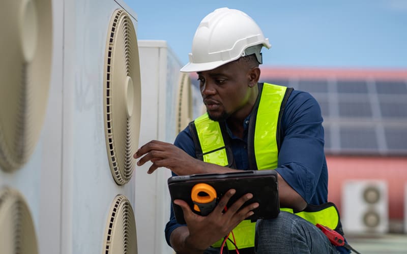 Heat pump tune-up and maintenance services being performed by a HVAC technician in St. Louis, Missouri