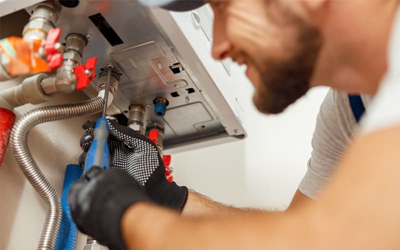 HVAC technician repairing a humidifier in a home in St. Louis, MO